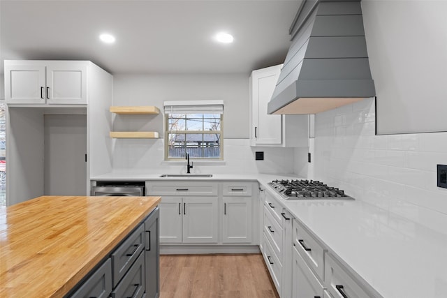 kitchen with sink, white cabinetry, wooden counters, and tasteful backsplash