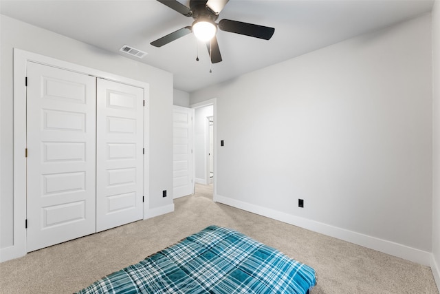 carpeted bedroom with ceiling fan and a closet