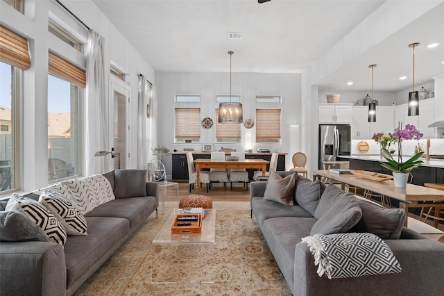 living room with a notable chandelier and light hardwood / wood-style flooring