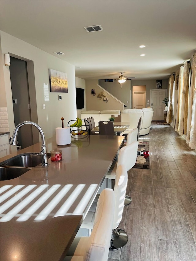 dining room with ceiling fan, sink, and hardwood / wood-style floors