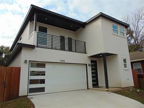 view of front of property featuring a balcony and a garage