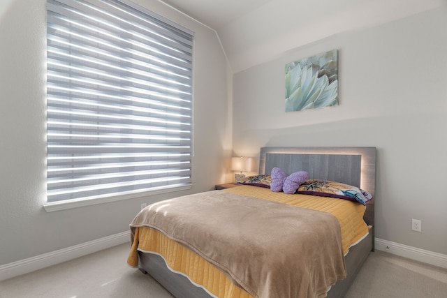 carpeted bedroom with lofted ceiling