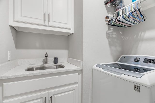 laundry area featuring washer / dryer, sink, and cabinets