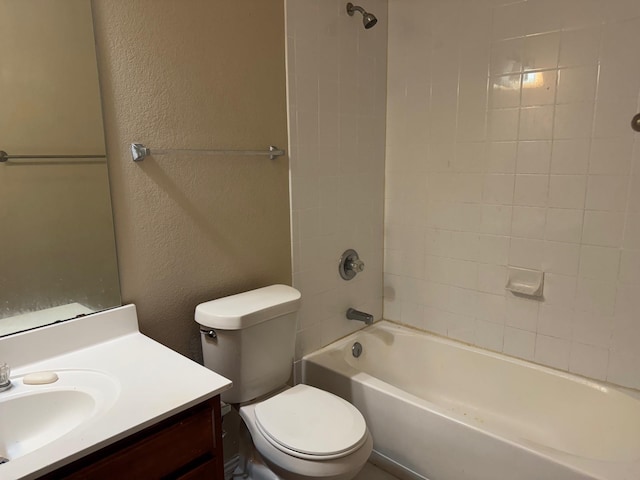 full bathroom featuring tiled shower / bath, vanity, and toilet