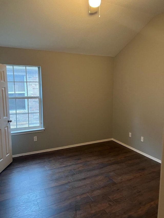 unfurnished room featuring lofted ceiling and dark hardwood / wood-style floors