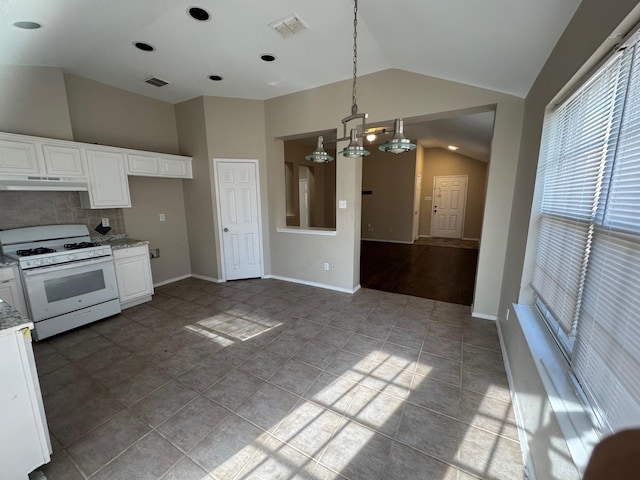 kitchen featuring white cabinetry, vaulted ceiling, tasteful backsplash, gas range gas stove, and hanging light fixtures