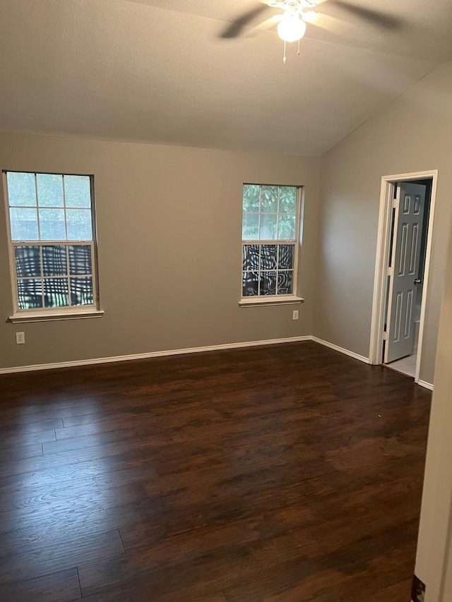 unfurnished room with lofted ceiling, dark hardwood / wood-style flooring, ceiling fan, and a wealth of natural light