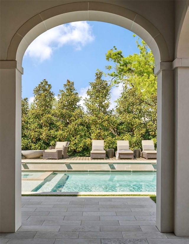 view of swimming pool with a patio, pool water feature, and grilling area