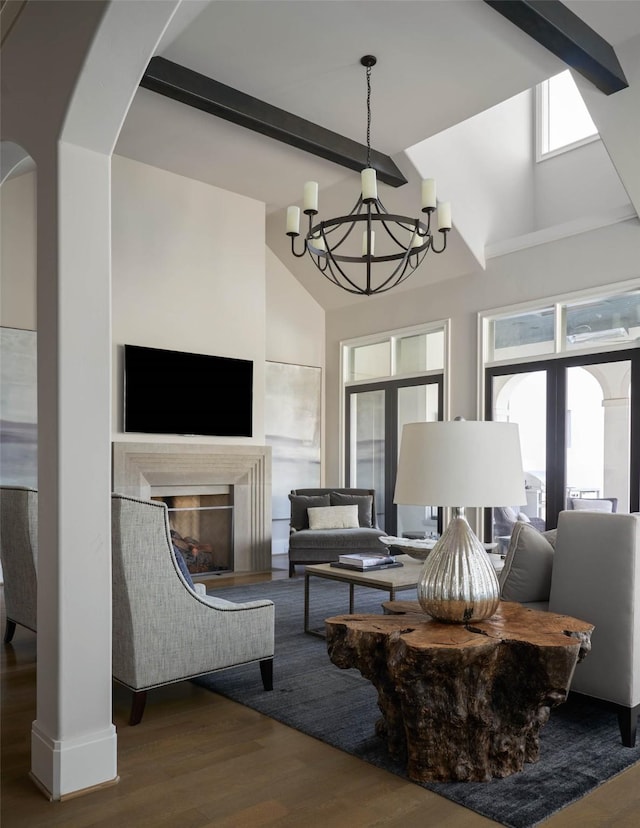 living room with a high ceiling, french doors, hardwood / wood-style flooring, beam ceiling, and an inviting chandelier