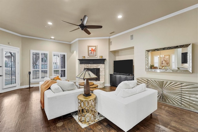 living room featuring ceiling fan, dark hardwood / wood-style floors, ornamental molding, and a fireplace