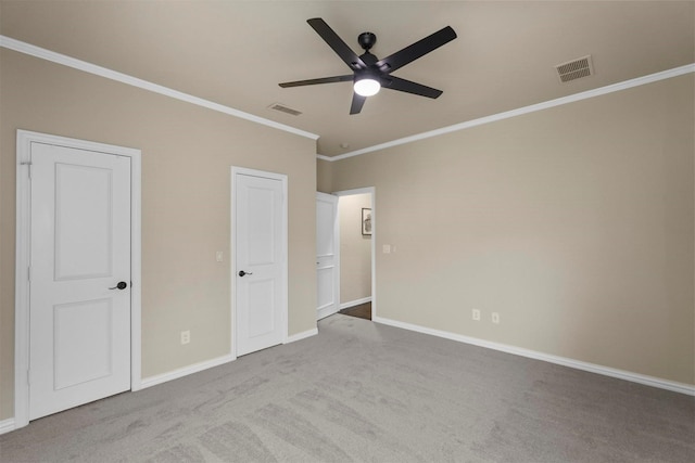 unfurnished bedroom with ceiling fan, light colored carpet, and crown molding