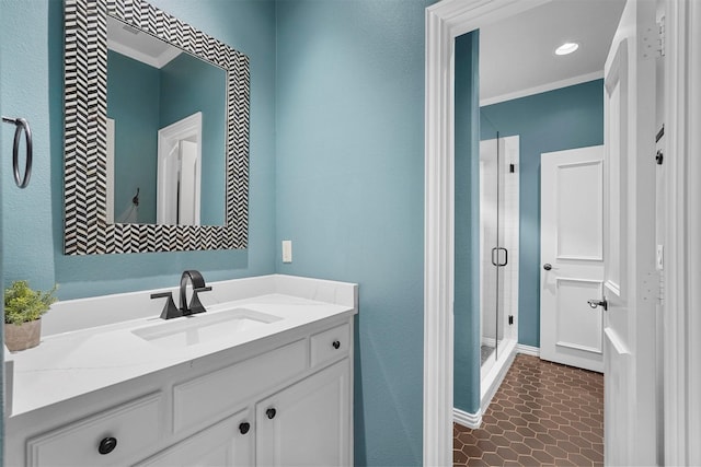 bathroom featuring a shower with shower door, vanity, and ornamental molding