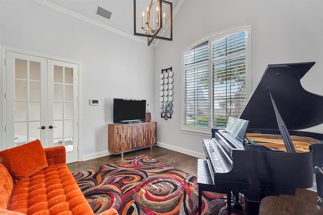 interior space with dark hardwood / wood-style flooring, crown molding, a chandelier, and french doors