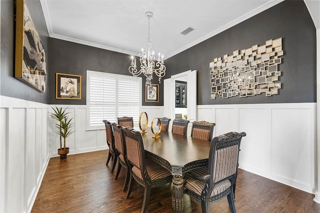 dining space with dark hardwood / wood-style flooring, crown molding, and an inviting chandelier