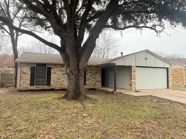 single story home with a garage and a front lawn