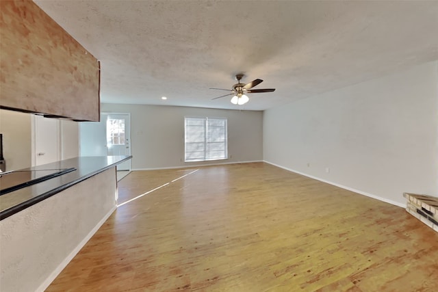 unfurnished living room with ceiling fan and light hardwood / wood-style flooring