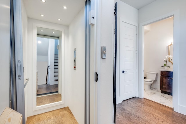 hall featuring elevator and light wood-type flooring