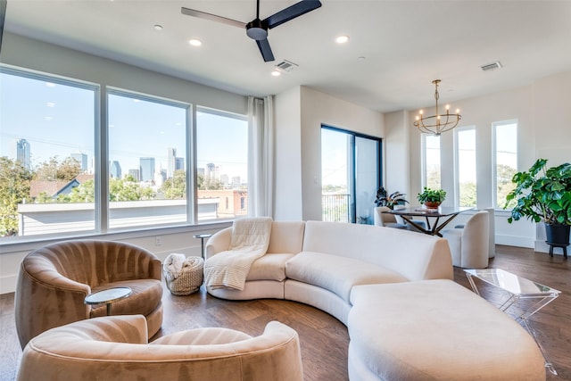 living room with dark hardwood / wood-style floors and ceiling fan with notable chandelier