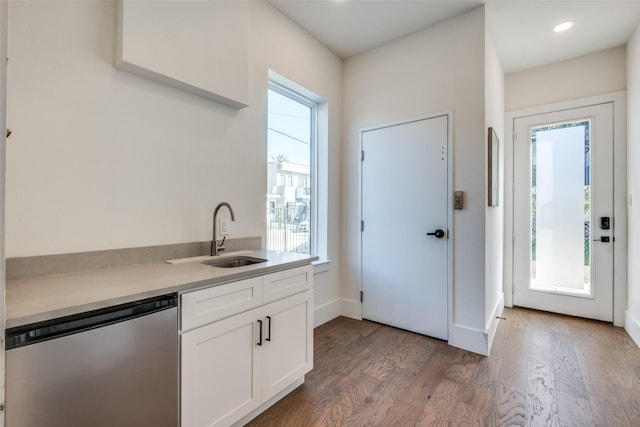 kitchen with white cabinetry, dishwasher, dark hardwood / wood-style flooring, and sink