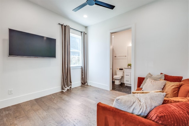 bedroom with ceiling fan, ensuite bath, and hardwood / wood-style flooring