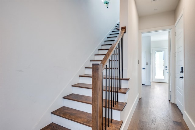 staircase with hardwood / wood-style floors