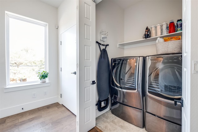 laundry area featuring washer and clothes dryer and light wood-type flooring