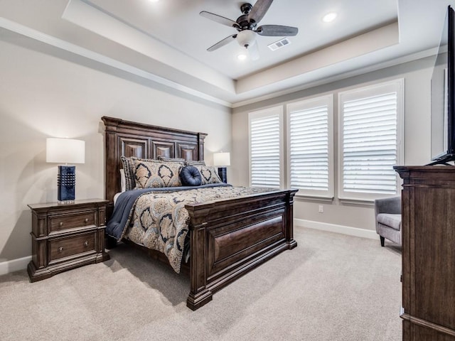 carpeted bedroom featuring ceiling fan and a raised ceiling