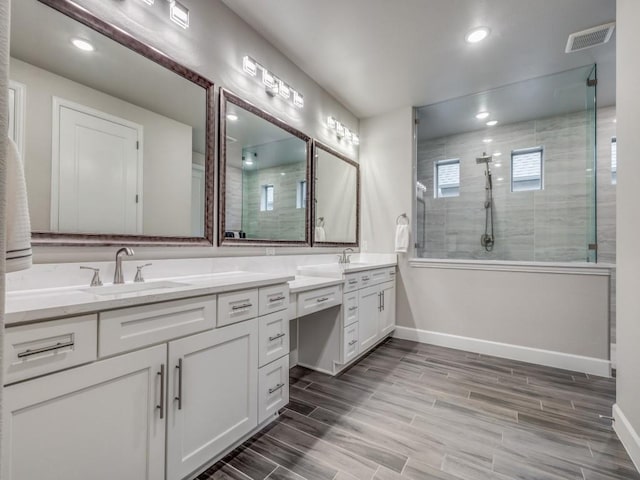 bathroom featuring a tile shower and vanity