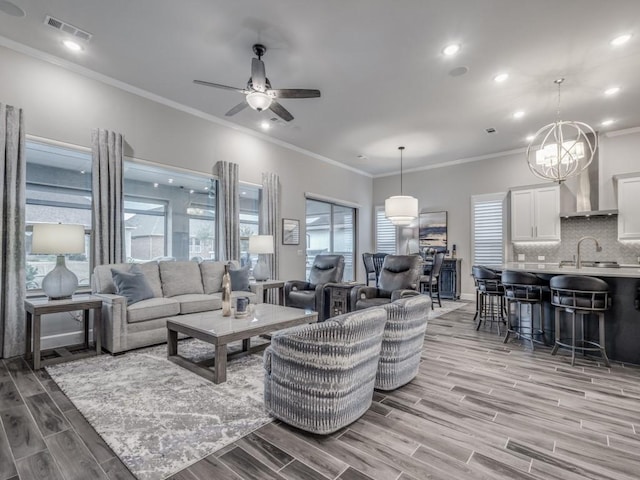 living room featuring ornamental molding and ceiling fan with notable chandelier