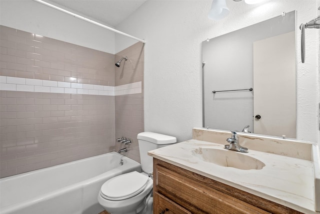 full bathroom with tiled shower / bath, vanity, and toilet