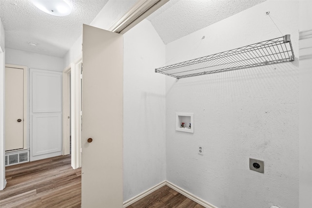 laundry room with hardwood / wood-style floors, electric dryer hookup, washer hookup, and a textured ceiling