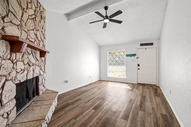 unfurnished living room featuring a textured ceiling, a fireplace, vaulted ceiling with beams, ceiling fan, and dark hardwood / wood-style floors