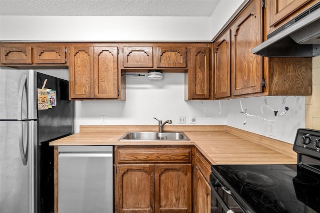 kitchen with sink, stainless steel appliances, and a textured ceiling