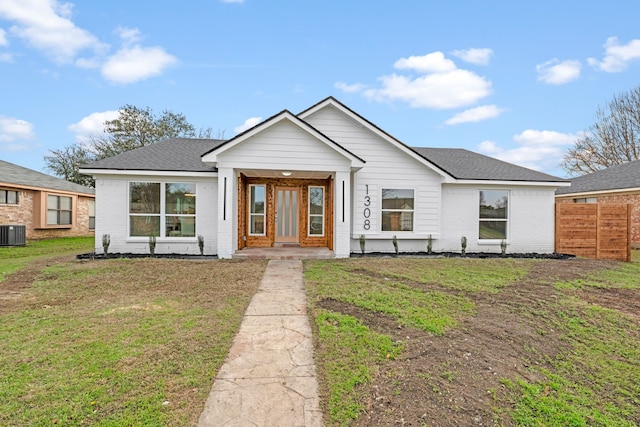 view of front of home featuring cooling unit and a front yard