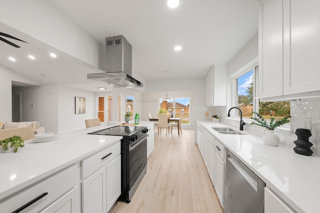 kitchen with stainless steel dishwasher, wall chimney exhaust hood, electric range, white cabinets, and sink