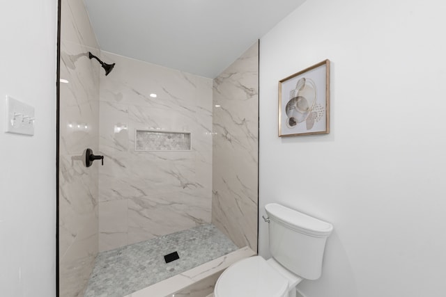 bathroom with toilet and a tile shower