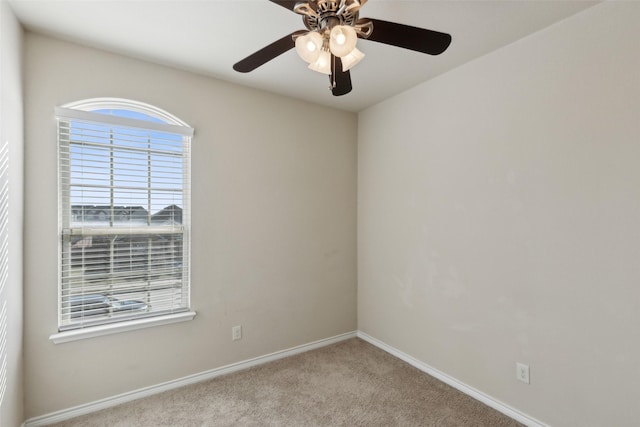 carpeted spare room featuring ceiling fan