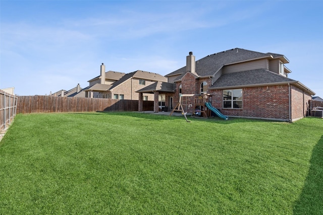 rear view of property with a playground and a lawn