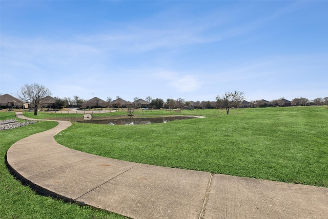 view of community featuring a water view and a lawn