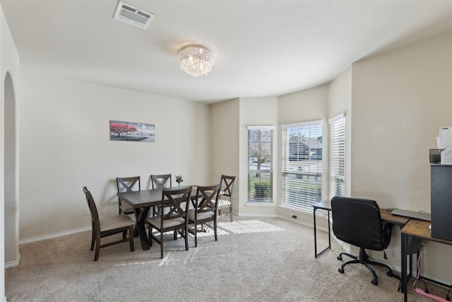 home office with light colored carpet and a chandelier