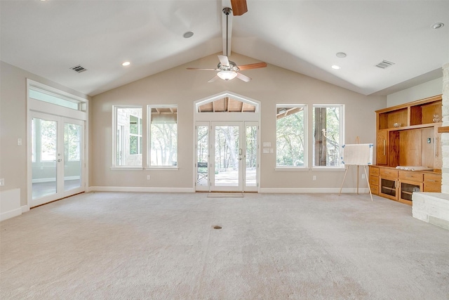 unfurnished living room featuring french doors, ceiling fan, vaulted ceiling, and light carpet