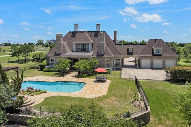 view of swimming pool featuring a lawn, a patio area, and an outdoor fire pit