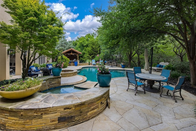 view of patio / terrace featuring a pool with hot tub