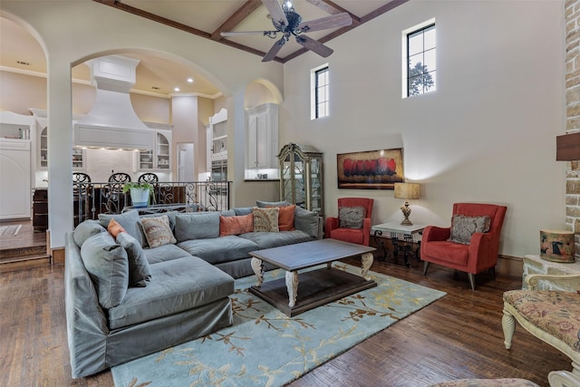 living room featuring beamed ceiling, ceiling fan, and dark hardwood / wood-style flooring