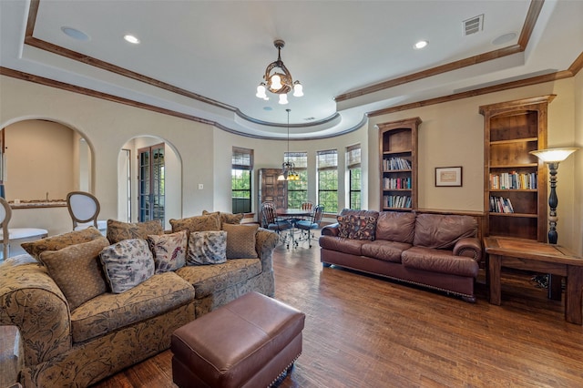 living room featuring an inviting chandelier, ornamental molding, and dark hardwood / wood-style flooring