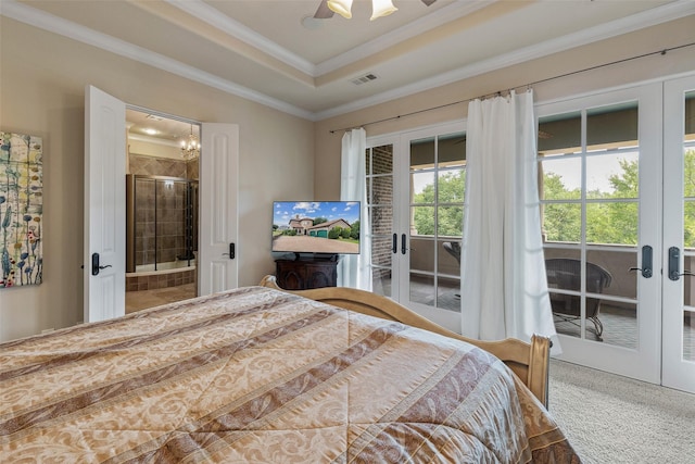 bedroom featuring crown molding, french doors, a tray ceiling, ensuite bathroom, and ceiling fan with notable chandelier