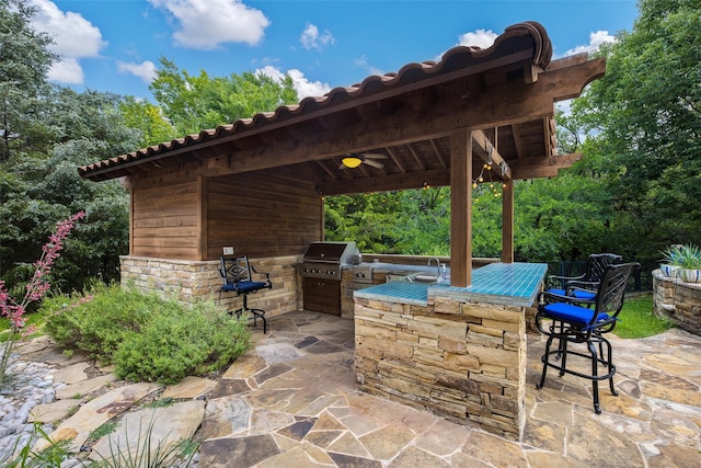 view of patio / terrace featuring exterior kitchen, grilling area, and a wet bar