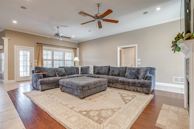 living room featuring ceiling fan, ornamental molding, and hardwood / wood-style floors