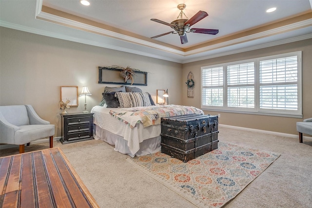 carpeted bedroom with ornamental molding, ceiling fan, and a tray ceiling