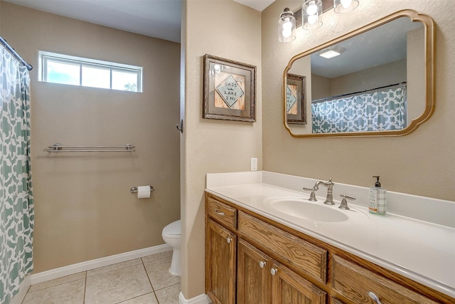 bathroom with tile patterned flooring, vanity, and toilet